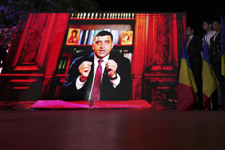 Presidential candidate George Simion is shown on a screen at the meeting of his supporters after polls closed for the first round of the country's presidential election redo in Bucharest, Romania, Sunday, May 4, 2025. (AP Photo/Andreea Alexandru)