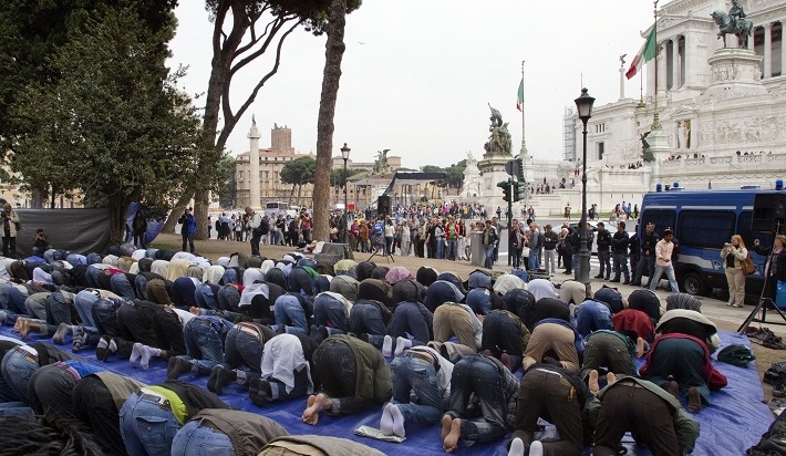 Muslims pray in Rome's Piazza Venezia Square, with the monument of the Unknown Soldier in the background at right, demanding religious freedom in Italy, Friday, April 22, 2011. Muslims living in Italy gathered in Rome's famous Piazza Venezia to conduct their Friday prayers and demand religious freedom in Italy as the Vatican began its Easter celebrations. (AP Photo/Andrew Medichini)